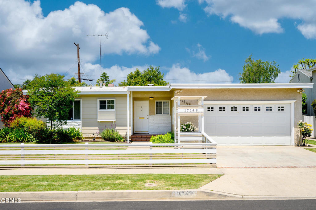 a front view of a house with a garden and plants