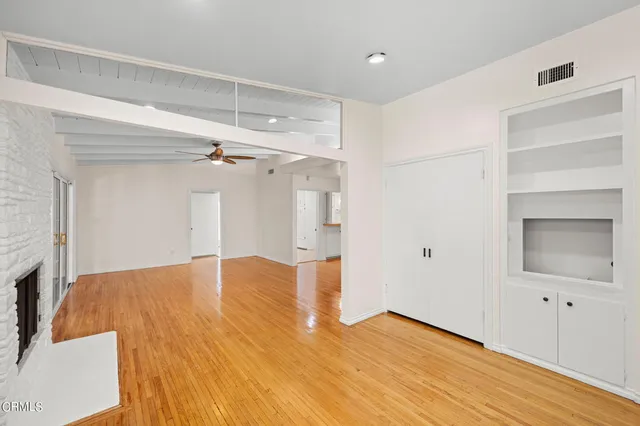 a view of empty room with wooden floor and cabinet