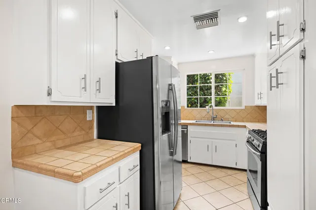 a kitchen with white cabinets and sink
