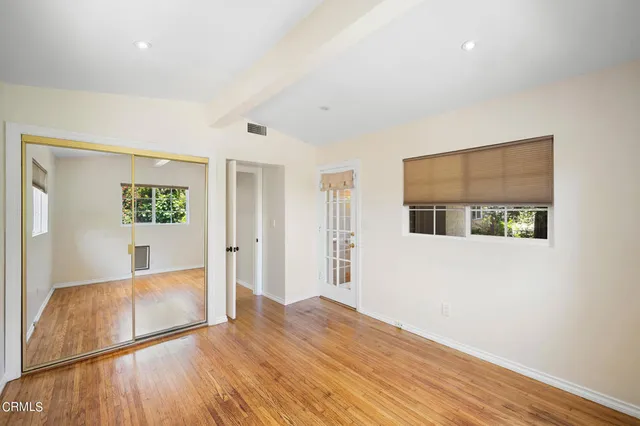 a view of a big room with wooden floor and windows