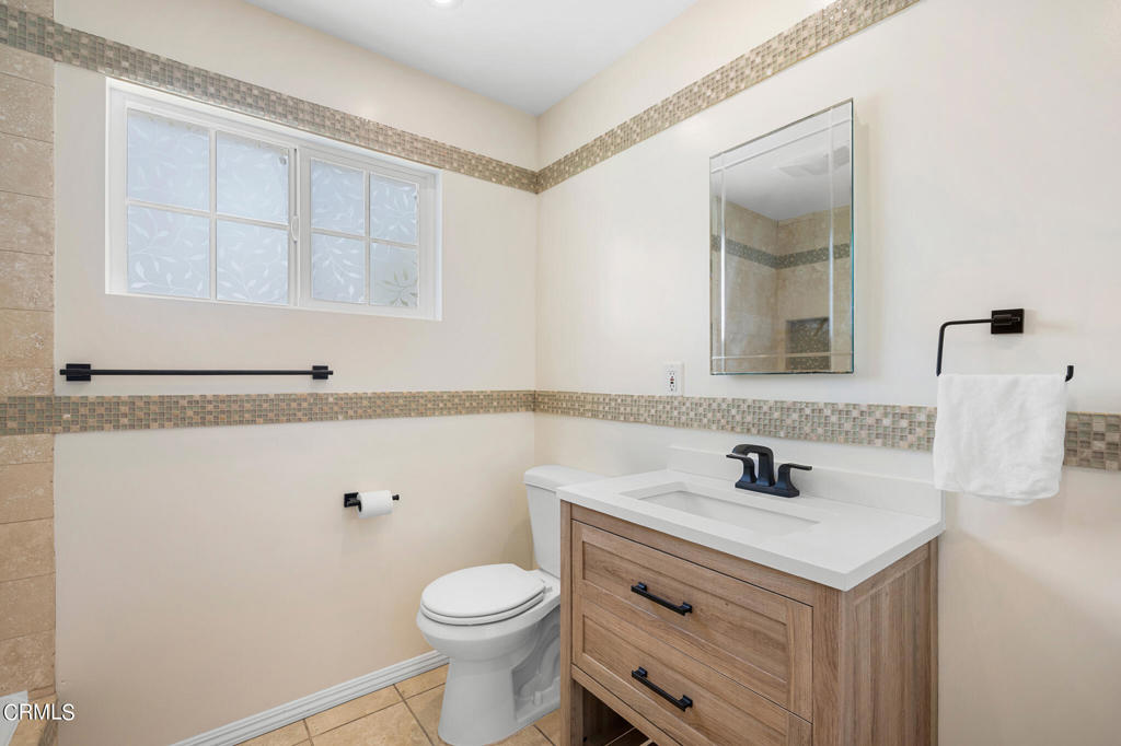 17149 Bullock Street Encino, CA 91316 - Photo 22 of 32 a bathroom with a sink a toilet and mirror
