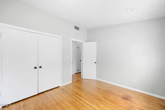 a view of an empty room with wooden floor