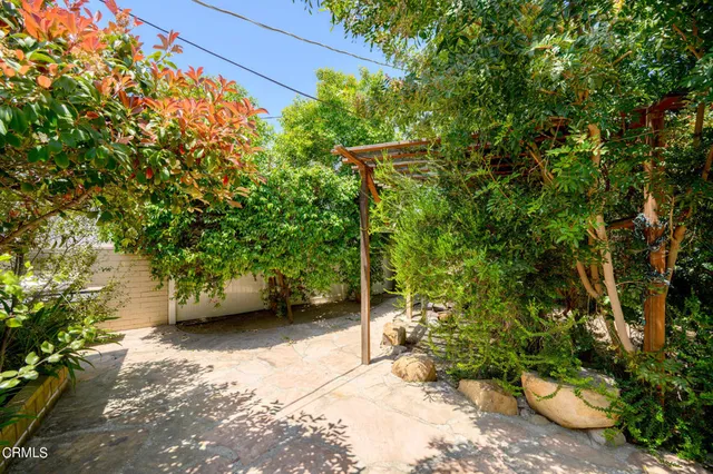 a view of a backyard with table and chairs and potted plants