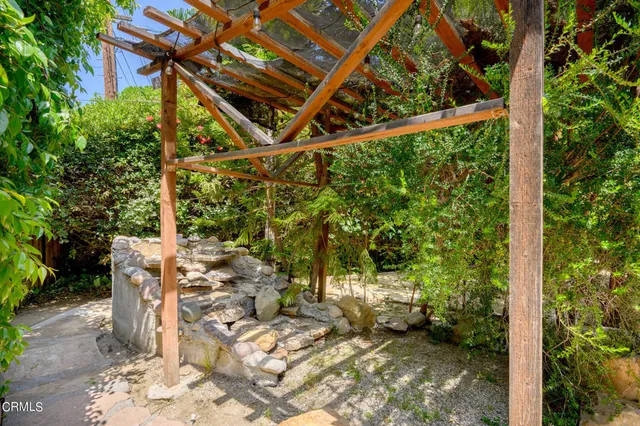a backyard of a house with a large tree and plants