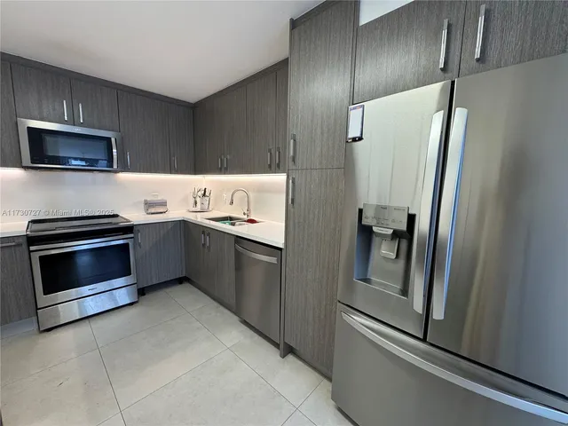 a kitchen with stainless steel appliances granite countertop a refrigerator and a stove