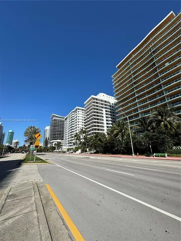 a city street with tall buildings in the background
