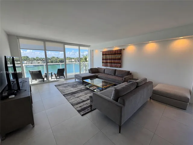 a living room with furniture and a floor to ceiling window