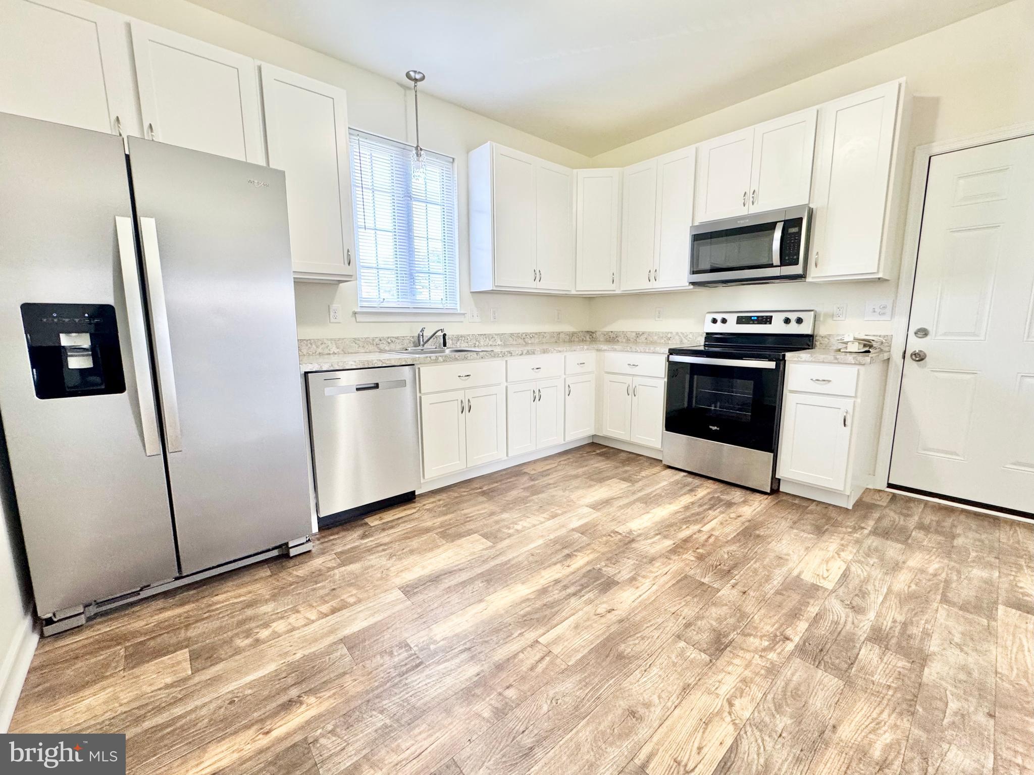 656 Venue Drive Dover, DE 19901 - Photo 14 of 29 a kitchen with granite countertop a refrigerator sink and microwave