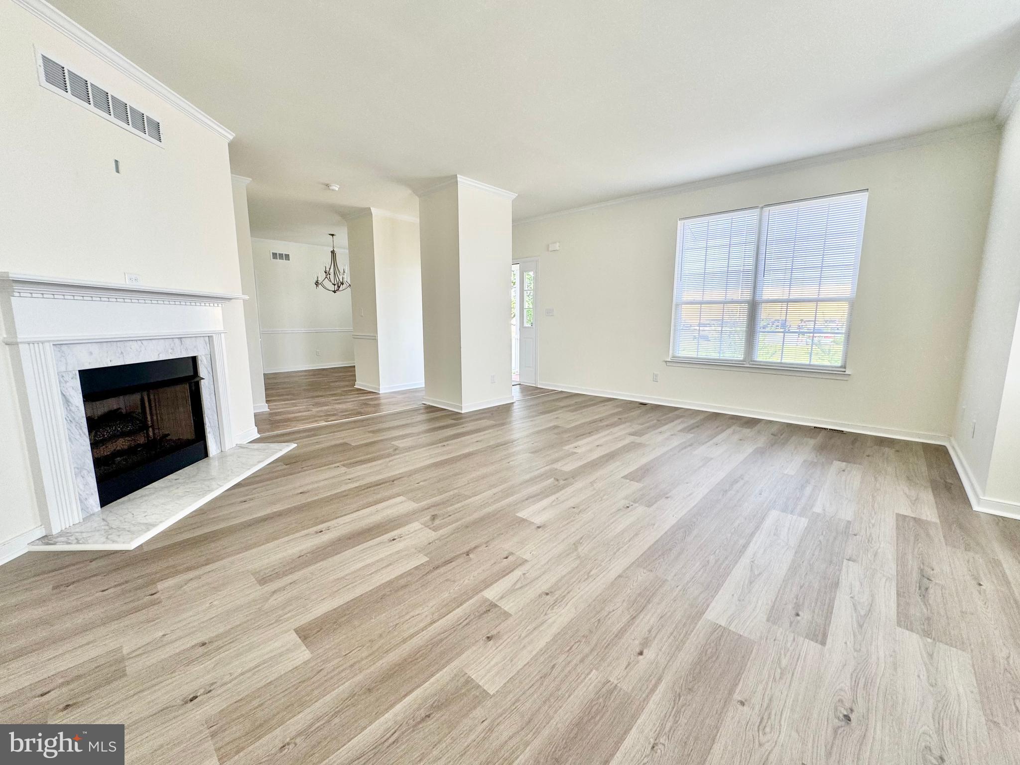 656 Venue Drive Dover, DE 19901 - Photo 8 of 29 an empty room with wooden floor fireplace and windows