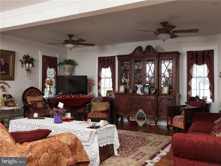 77 Petty Road Cranbury, NJ 08512 - Photo 19 of 32 a living room with furniture a fireplace and a flat screen tv