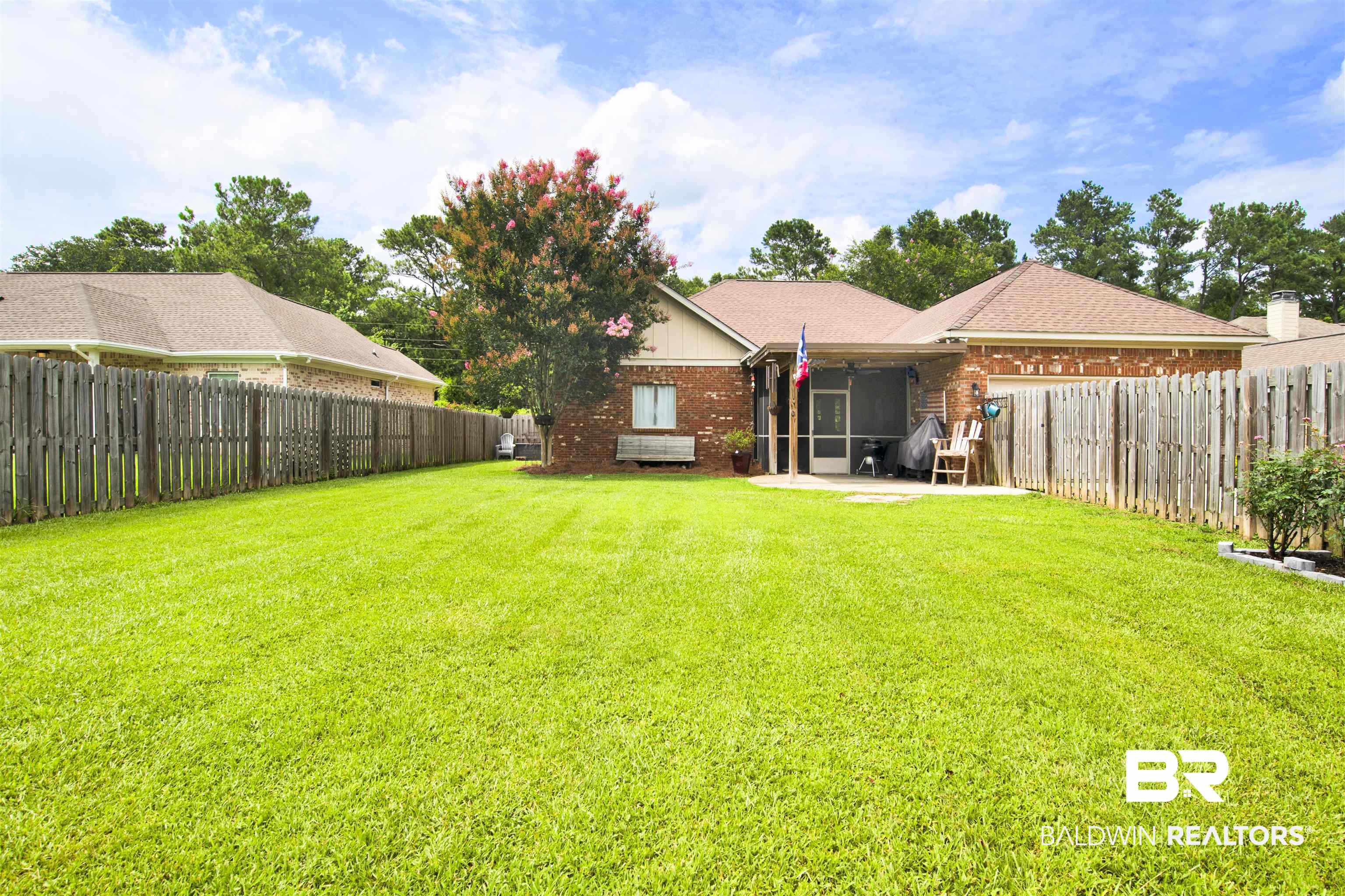 10368 Gayfer Rd Extension Fairhope, AL 36532 - Photo 40 of 43 Expansive backyard featuring a manicured lawn, full privacy fencing, and a covered screened patio