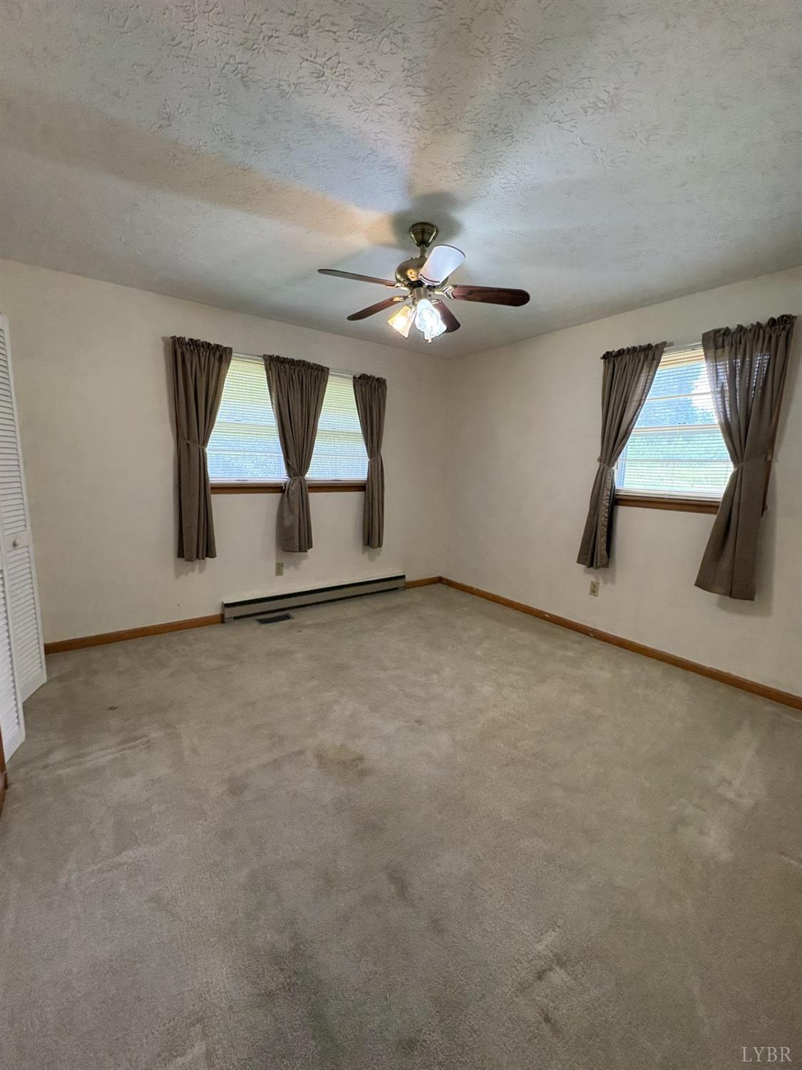 1796 Owens Mill Road Gretna, VA 24557 - Photo 11 of 20 an empty room with windows and fan