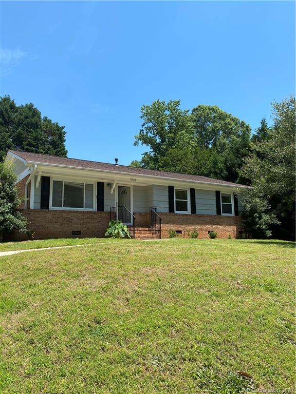 a front view of house with yard and trees