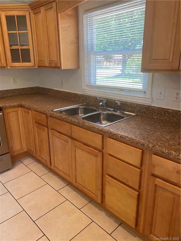 7323 Idlewild Road Charlotte, NC 28212 - Photo 4 of 13 a kitchen with granite countertop cabinets sink and window