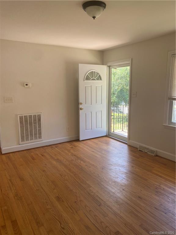 7323 Idlewild Road Charlotte, NC 28212 - Photo 6 of 13 an empty room with wooden floor and windows