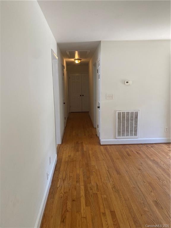 7323 Idlewild Road Charlotte, NC 28212 - Photo 7 of 13 a view of a hallway with wooden floor