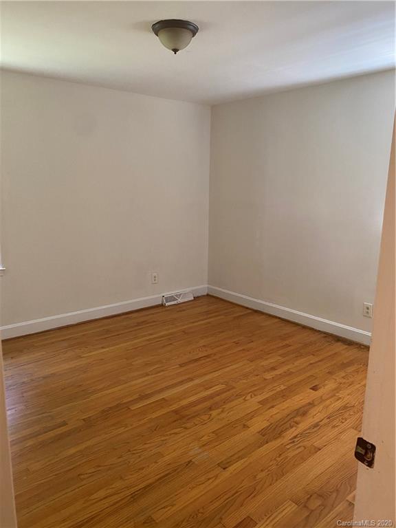7323 Idlewild Road Charlotte, NC 28212 - Photo 9 of 13 a view of an empty room with wooden floor
