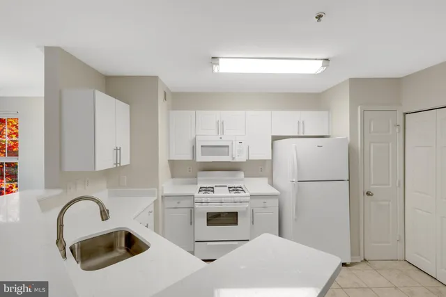 a kitchen with appliances a sink and cabinets