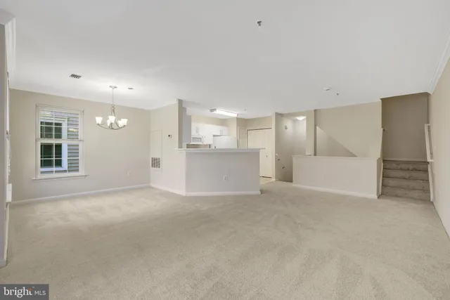 en empty room with window and chandelier fan