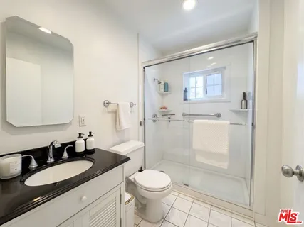 a bathroom with a granite countertop sink toilet and shower