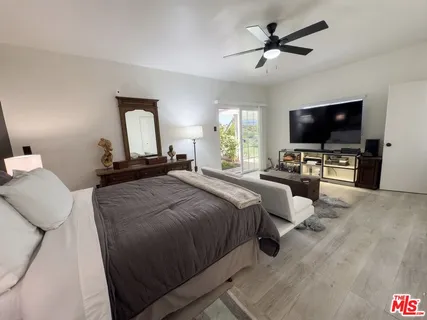 a bedroom with bed tv and window