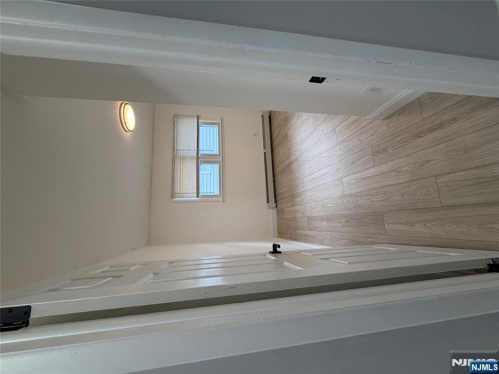 157 Cottage Place, Unit 2 Fairview, NJ 07022 - Photo 14 of 33 an empty room with wooden floor and windows