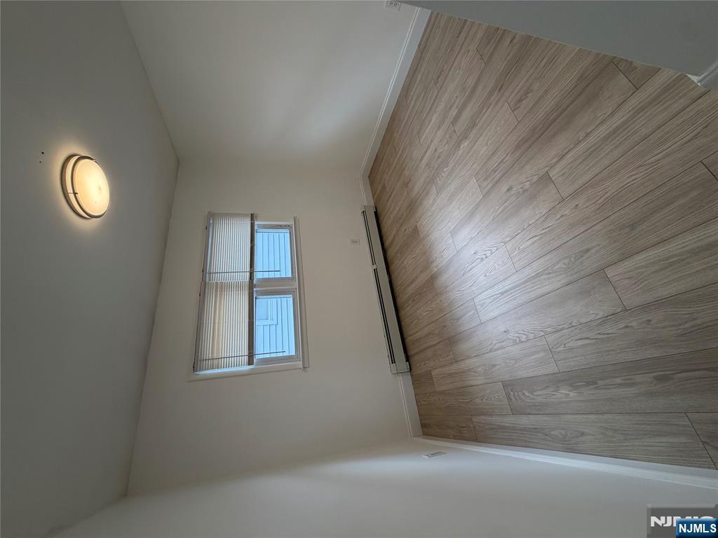 157 Cottage Place, Unit 2 Fairview, NJ 07022 - Photo 15 of 33 an empty room with wooden floor and windows