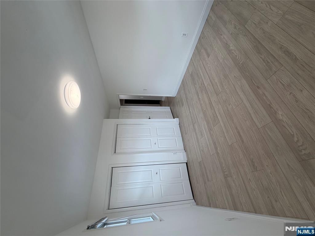 157 Cottage Place, Unit 2 Fairview, NJ 07022 - Photo 18 of 33 a view of an empty room with wooden floor and a window
