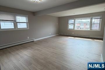 157 Cottage Place, Unit 2 Fairview, NJ 07022 - Photo 27 of 33 an empty room with wooden floor and windows