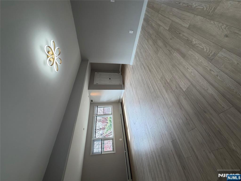 157 Cottage Place, Unit 2 Fairview, NJ 07022 - Photo 28 of 33 a view of an empty room with a window and wooden floor