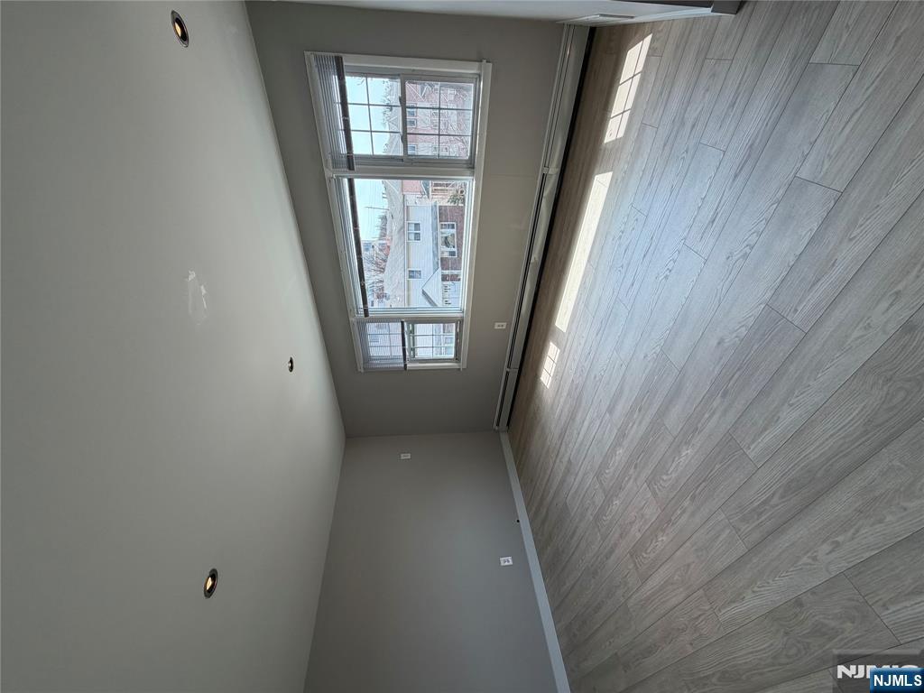 157 Cottage Place, Unit 2 Fairview, NJ 07022 - Photo 29 of 33 a view of an empty room with wooden floor and a window