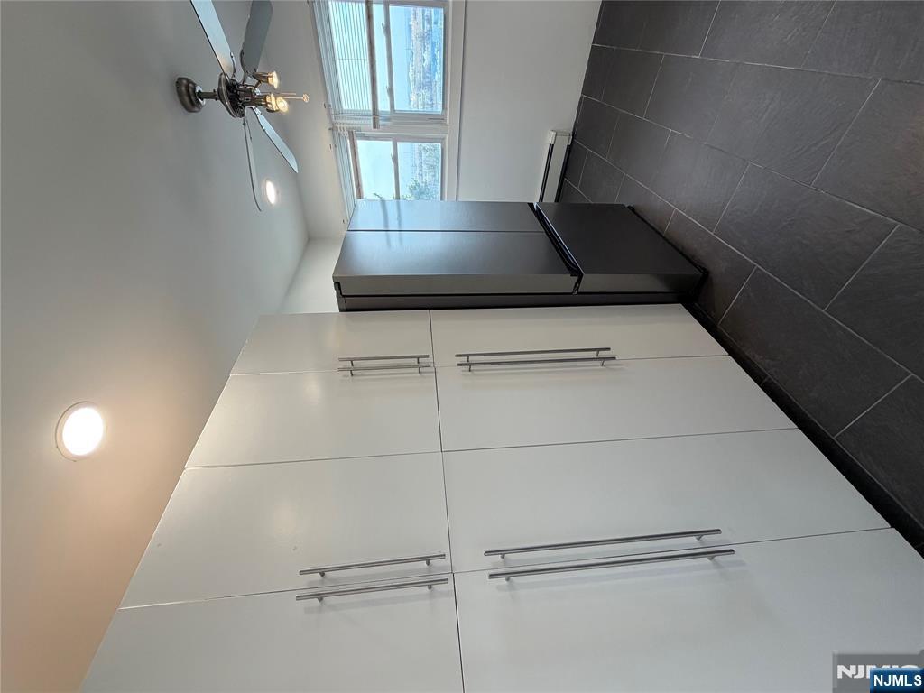 157 Cottage Place, Unit 2 Fairview, NJ 07022 - Photo 4 of 33 a view of a refrigerator in kitchen and an empty room
