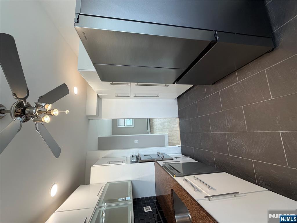 157 Cottage Place, Unit 2 Fairview, NJ 07022 - Photo 5 of 33 a kitchen with stainless steel appliances a refrigerator and a sink