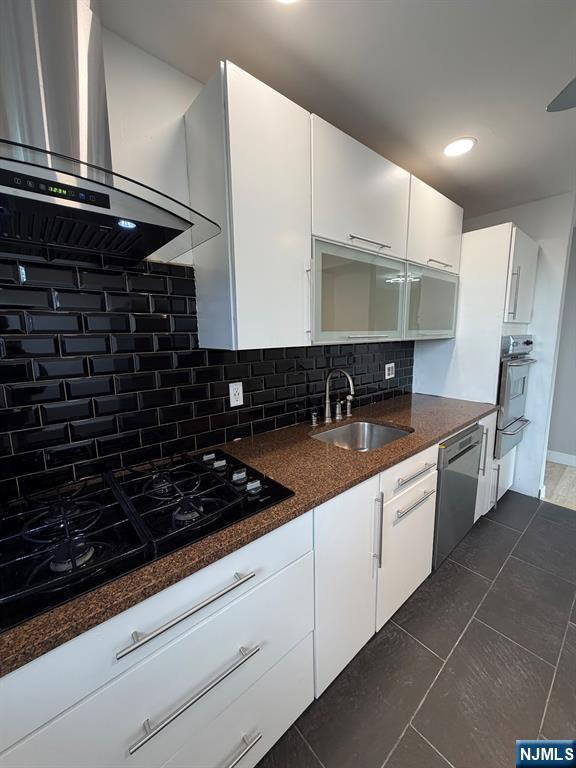 157 Cottage Place, Unit 2 Fairview, NJ 07022 - Photo 6 of 33 a kitchen with stainless steel appliances a sink and cabinets