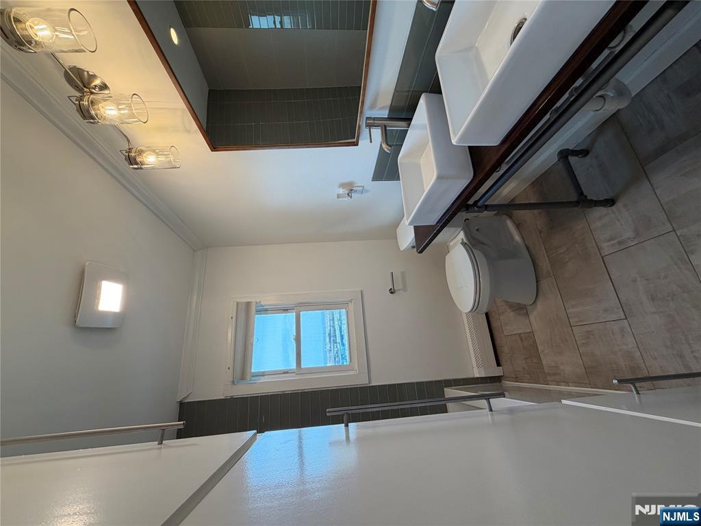 157 Cottage Place, Unit 2 Fairview, NJ 07022 - Photo 8 of 33 a bathroom with a toilet a sink and mirror