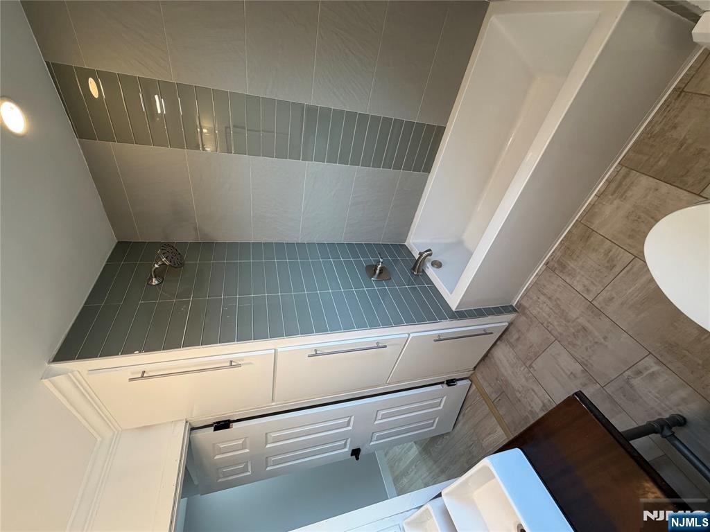 157 Cottage Place, Unit 2 Fairview, NJ 07022 - Photo 10 of 33 a bathroom with a bathtub a sink a toilet and a shower