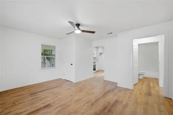 a view of empty room with wooden floor