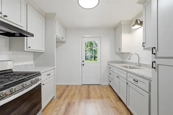 a kitchen with granite countertop a stove and a sink