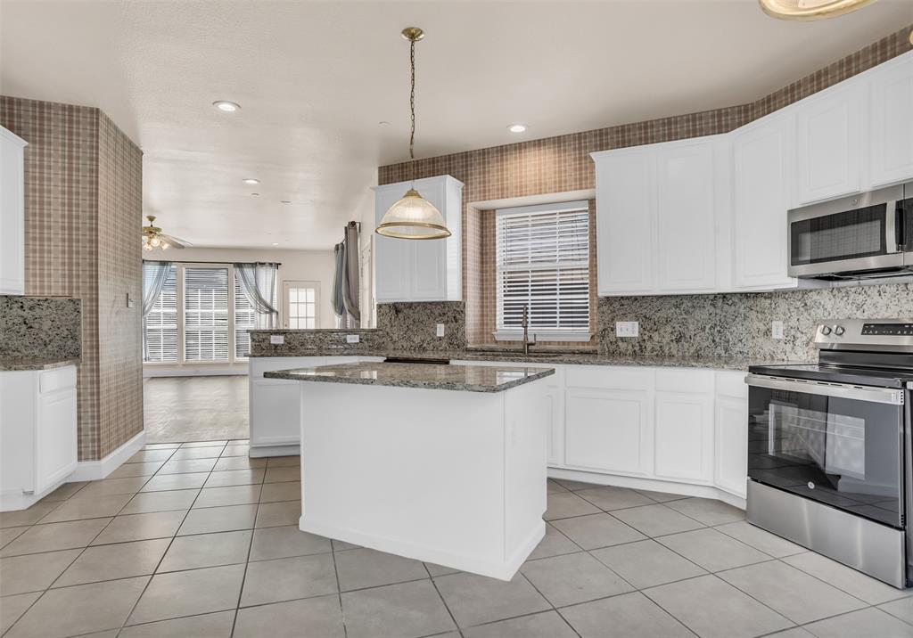 426 Richmond Street Irving, TX 75063 - Photo 16 of 33 a kitchen with stainless steel appliances granite countertop a stove a sink and a microwave
