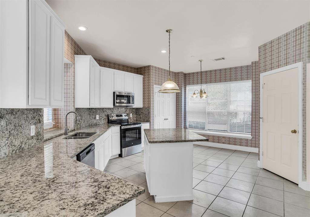 426 Richmond Street Irving, TX 75063 - Photo 19 of 33 a kitchen with granite countertop a refrigerator a sink and white cabinets