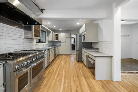 a large kitchen with stainless steel appliances granite countertop a stove and a refrigerator