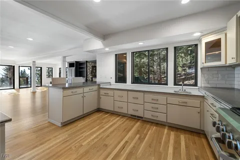 a large kitchen with stainless steel appliances granite countertop a lot of counter space and wooden floors