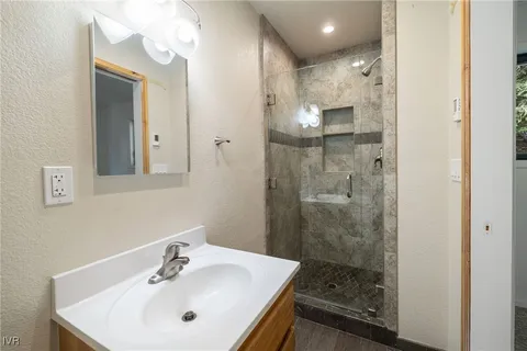 a bathroom with a sink a mirror a vanity and shower