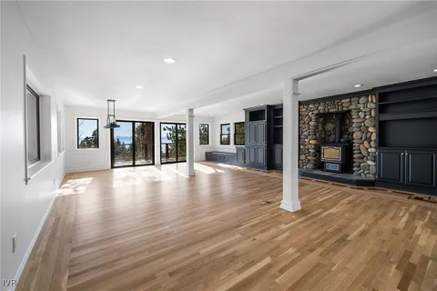 a view of a hall with wooden floor and a fireplace