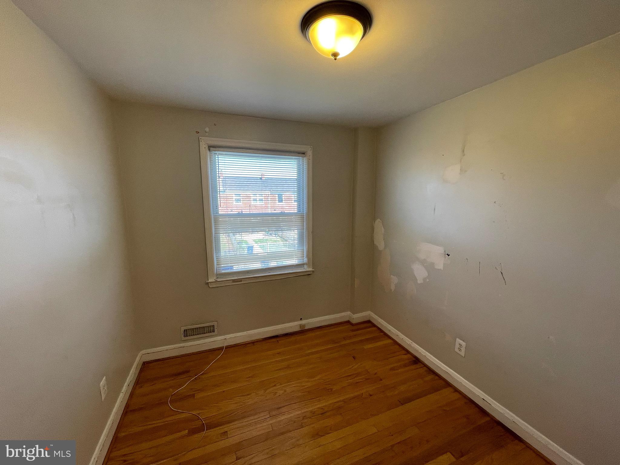 1640 Ingram Road Baltimore, MD 21239 - Photo 24 of 26 an empty room with wooden floor and windows