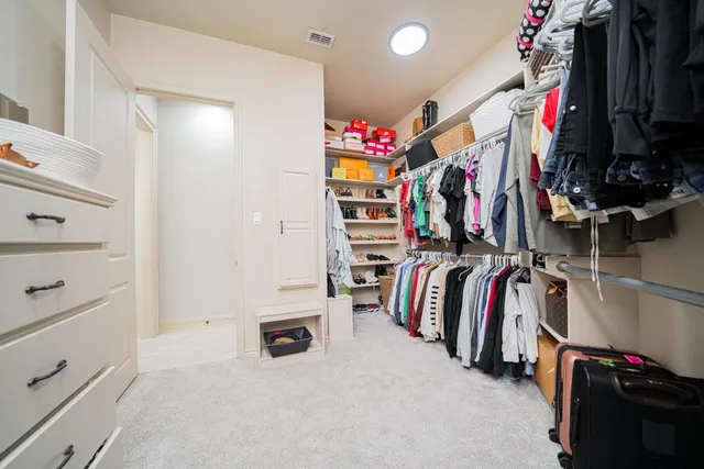 a view of walk in closet with clothes and shoes
