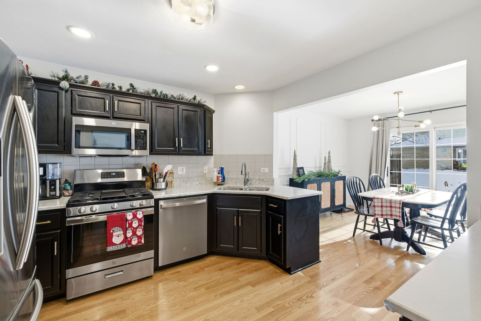 19320 Tramore Lane Mokena, IL 60448 - Photo 7 of 28 a kitchen with stainless steel appliances wooden cabinets and dining table