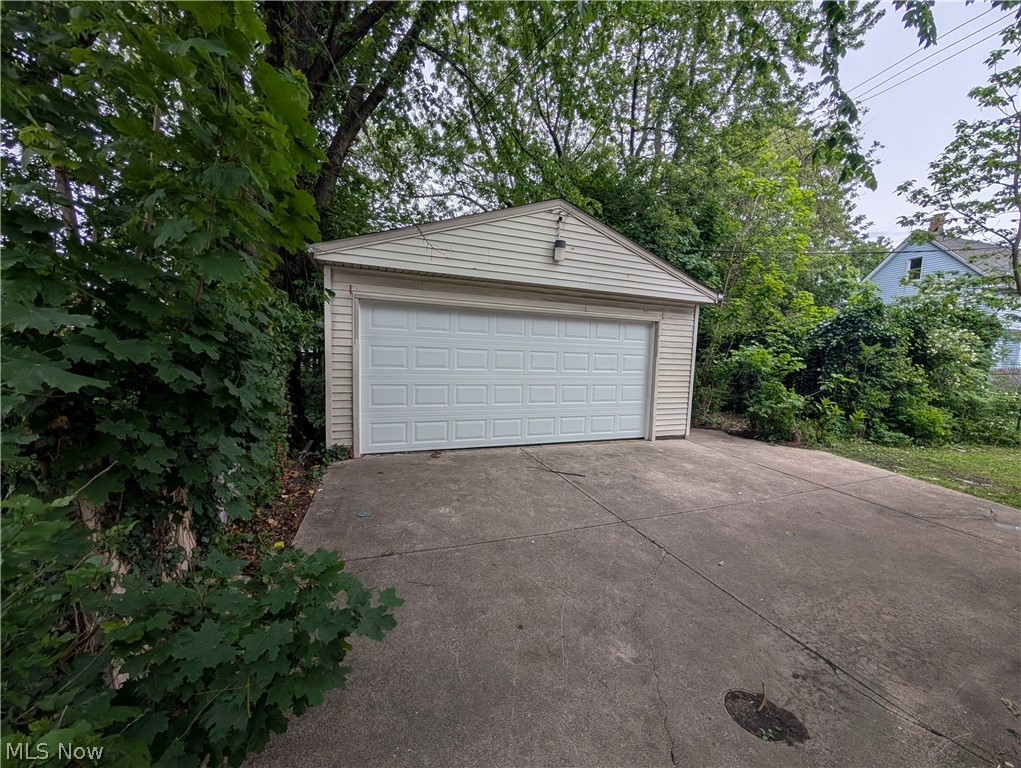 475 East 146th Street Cleveland, OH 44110 - Photo 28 of 28 Detached garage with horizontal siding, a gabled roofline, and a white panel garage door
