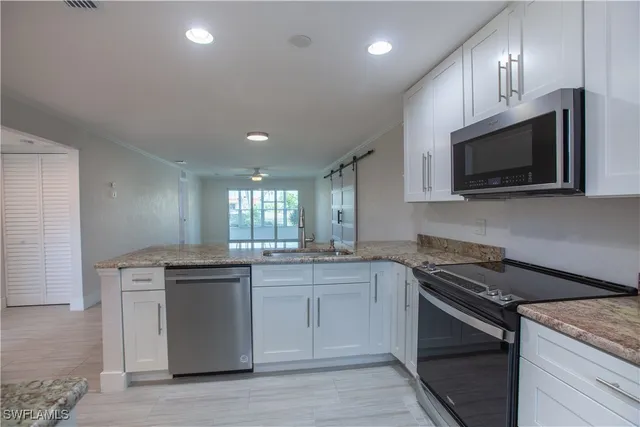 a view of a hallway with wooden floor and a kitchen
