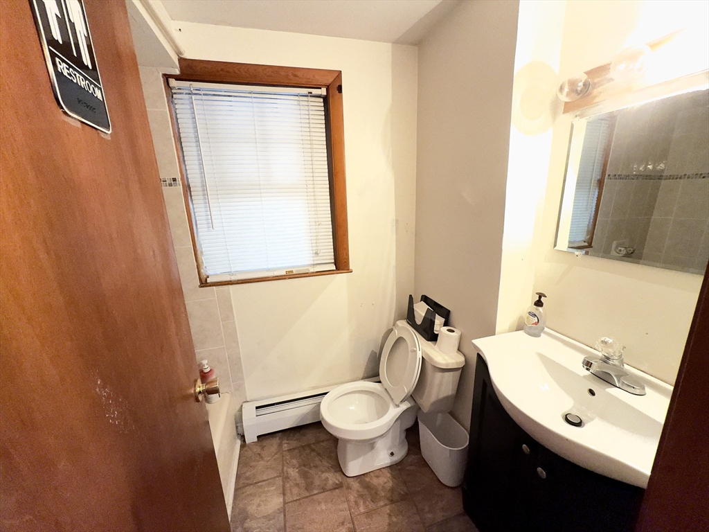 328 Brooks Street Worcester, MA 01606 - Photo 16 of 32 a bathroom with a toilet a sink and a mirror
